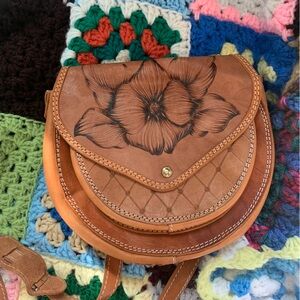 Vintage tooled leather crossbody bag with flower design and adjustable strap
